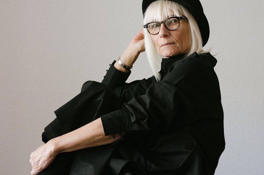woman in black long sleeve dress sitting on white chair