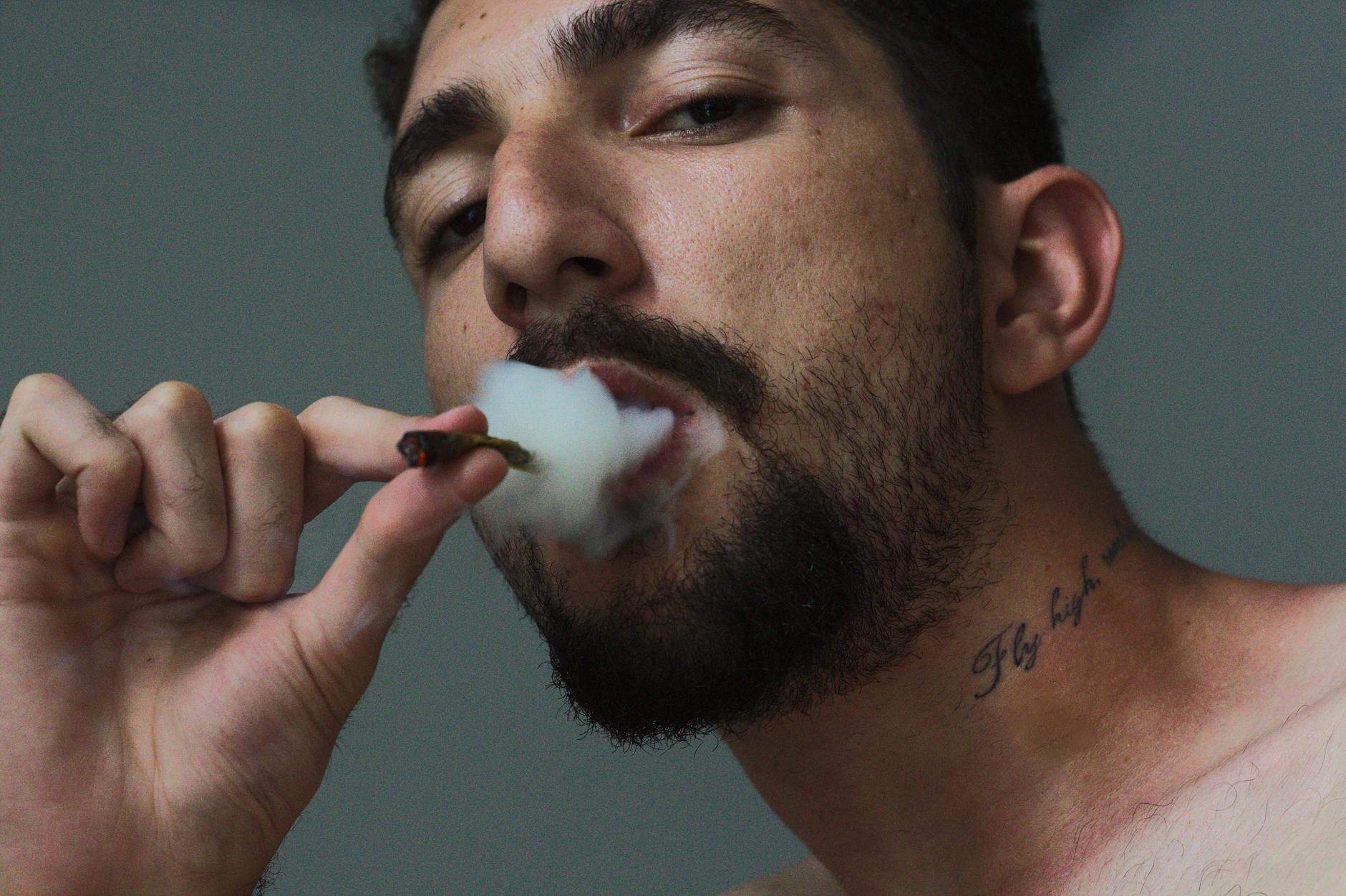 man smoking tobacco inside room