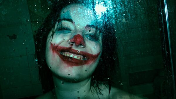 eerie joker smile behind wet glass