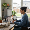 “Woman working at her desk with multiple screens while learning how to protect your creative work online and manage digital files safely.”