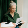 Older woman reading documents while experiencing a creative upgrade in your 40s