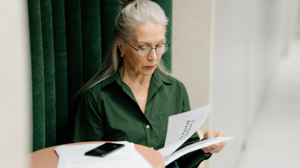 Older woman reading documents while experiencing a creative upgrade in your 40s