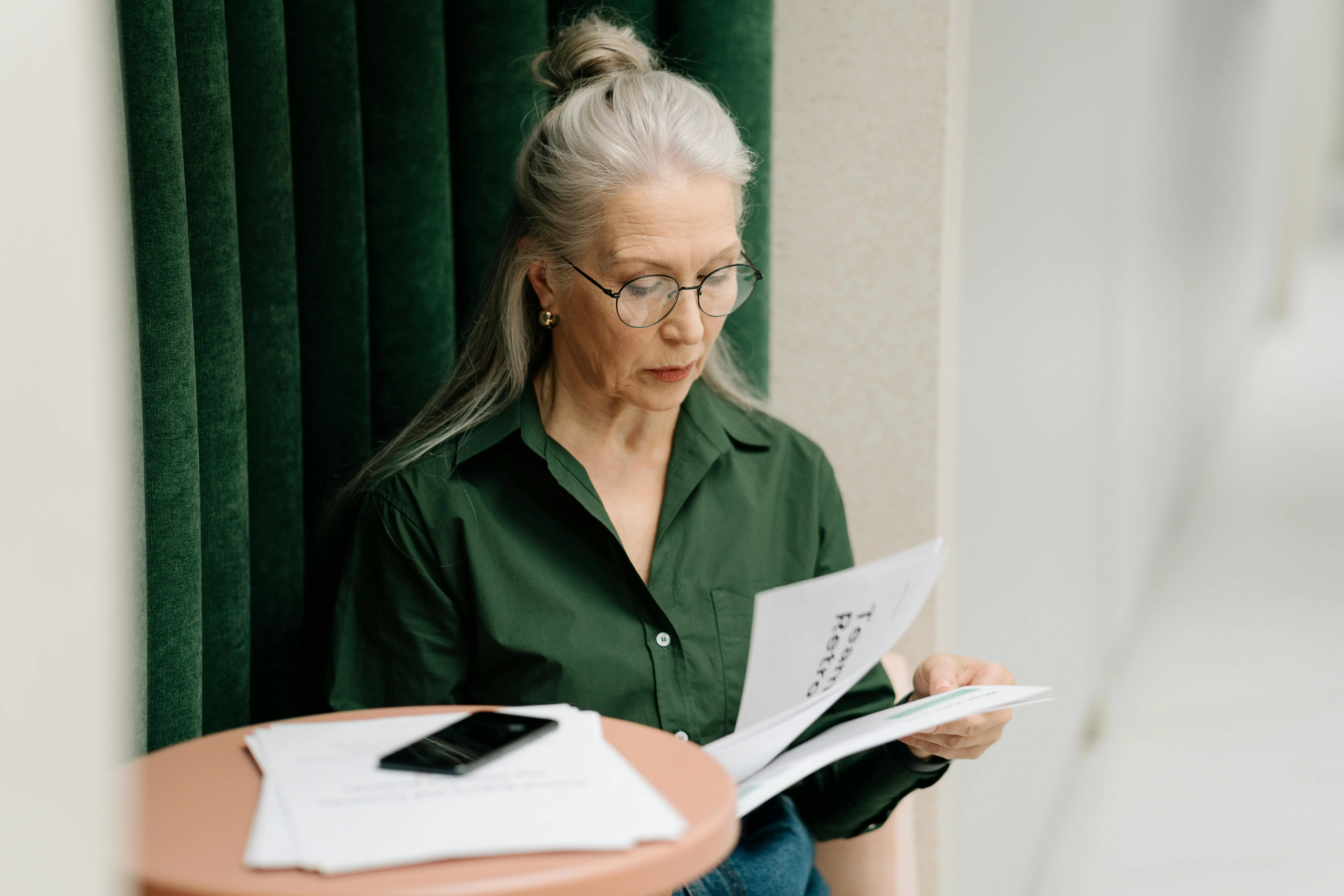 Older woman reading documents while experiencing a creative upgrade in your 40s