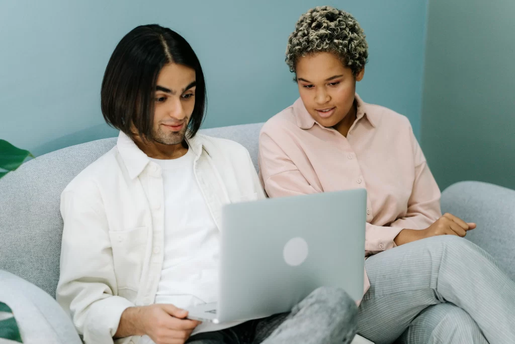Two adults looking at a laptop while exploring a creative upgrade in your 40s
