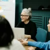 Smiling older woman leading a creative meeting, representing the rise of over-40 creators shaping modern workspaces.