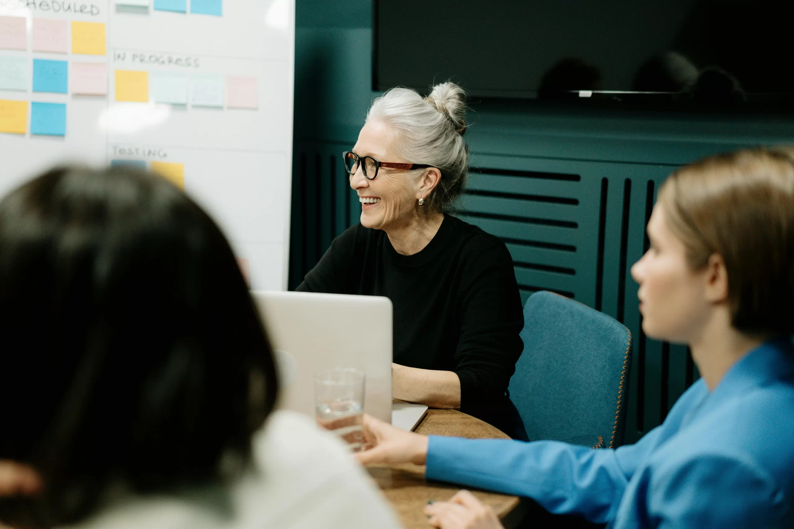 Smiling older woman leading a creative meeting, representing the rise of over-40 creators shaping modern workspaces.