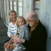 Father in his 50s enjoying a relaxed outdoor moment with his daughter and partner.