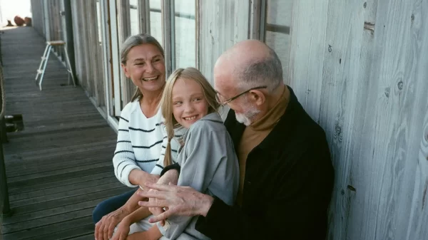 Father in his 50s enjoying a relaxed outdoor moment with his daughter and partner.