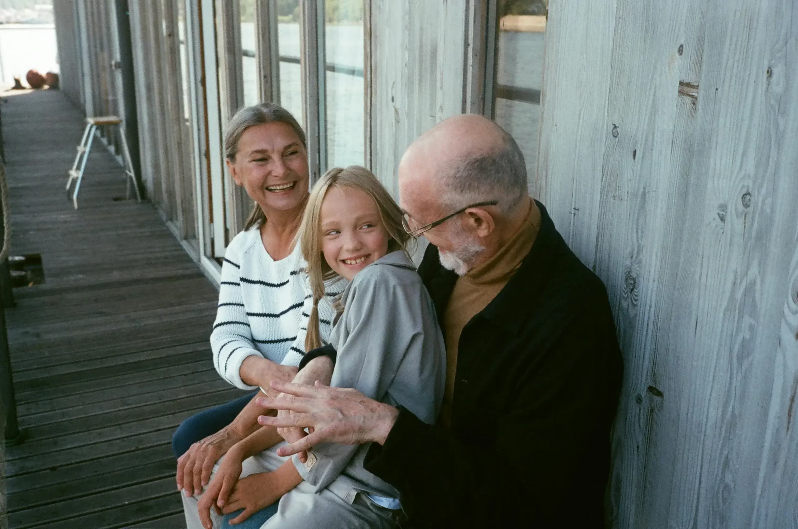 Father in his 50s enjoying a relaxed outdoor moment with his daughter and partner.