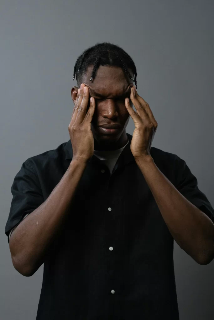 Man pressing his temples with his fingers during a headache
