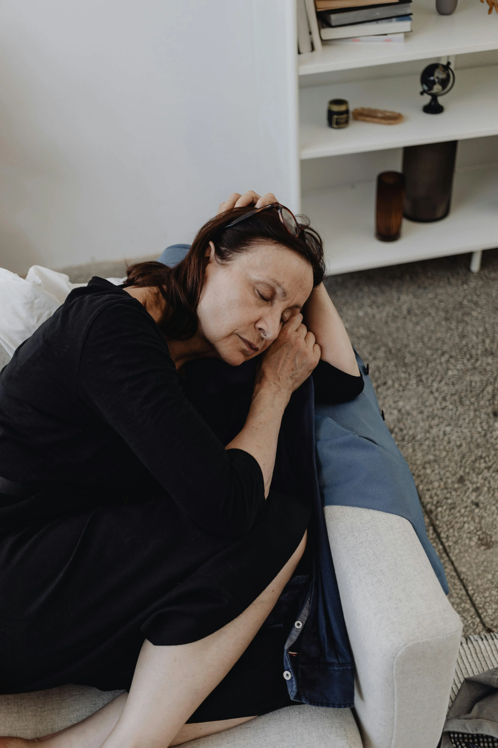 Woman in her 50s sleeping on a couch, illustrating how sleep hits different after 45.