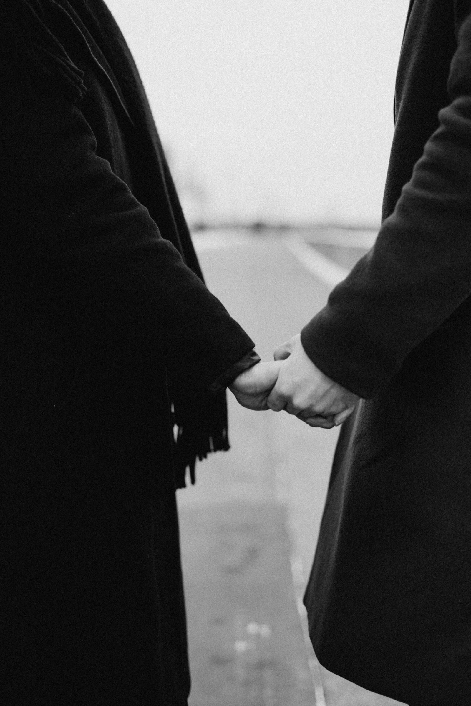 Two people holding hands while walking, symbolizing connection and shared travel rituals