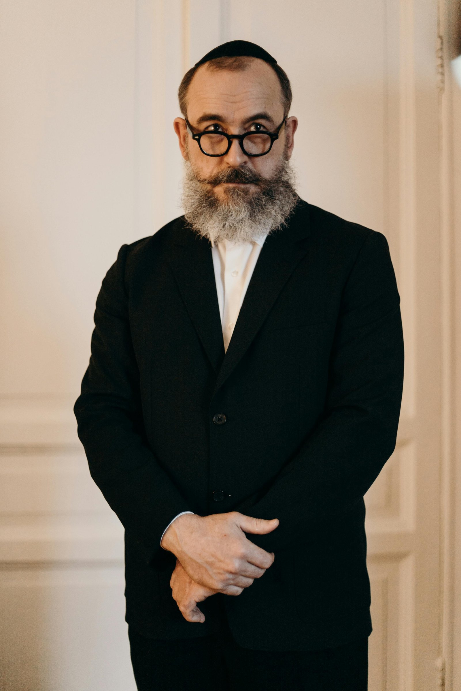 Middle-aged man standing calmly in formal wear, representing acceptance of body changes after 40