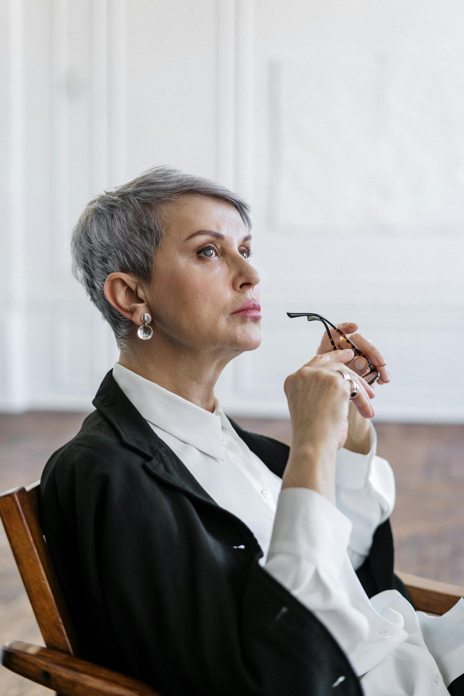 Thoughtful middle-aged woman holding her glasses while reflecting during a quiet moment.