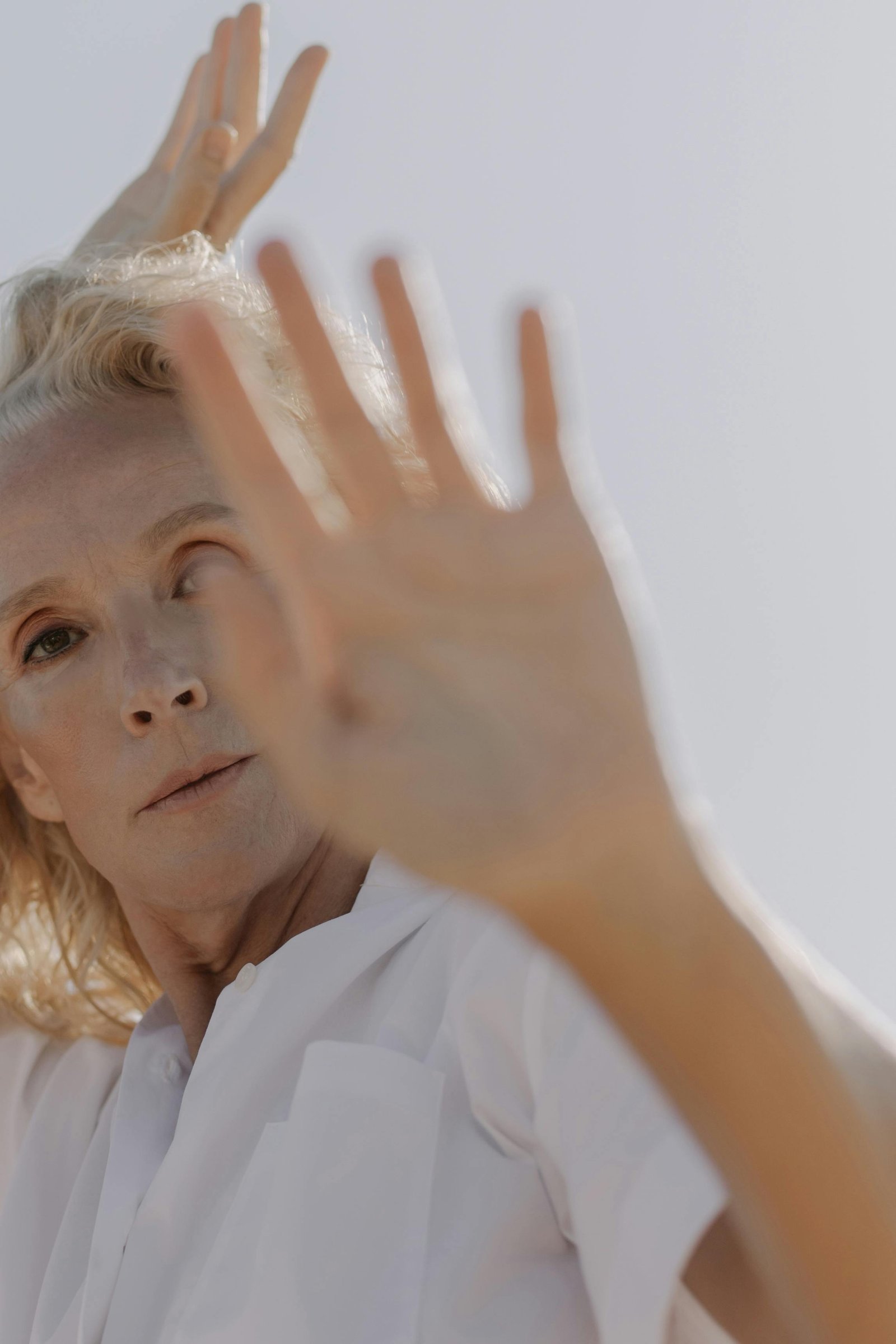 Older woman raising her hands outdoors, expressing freedom and midlife creativity