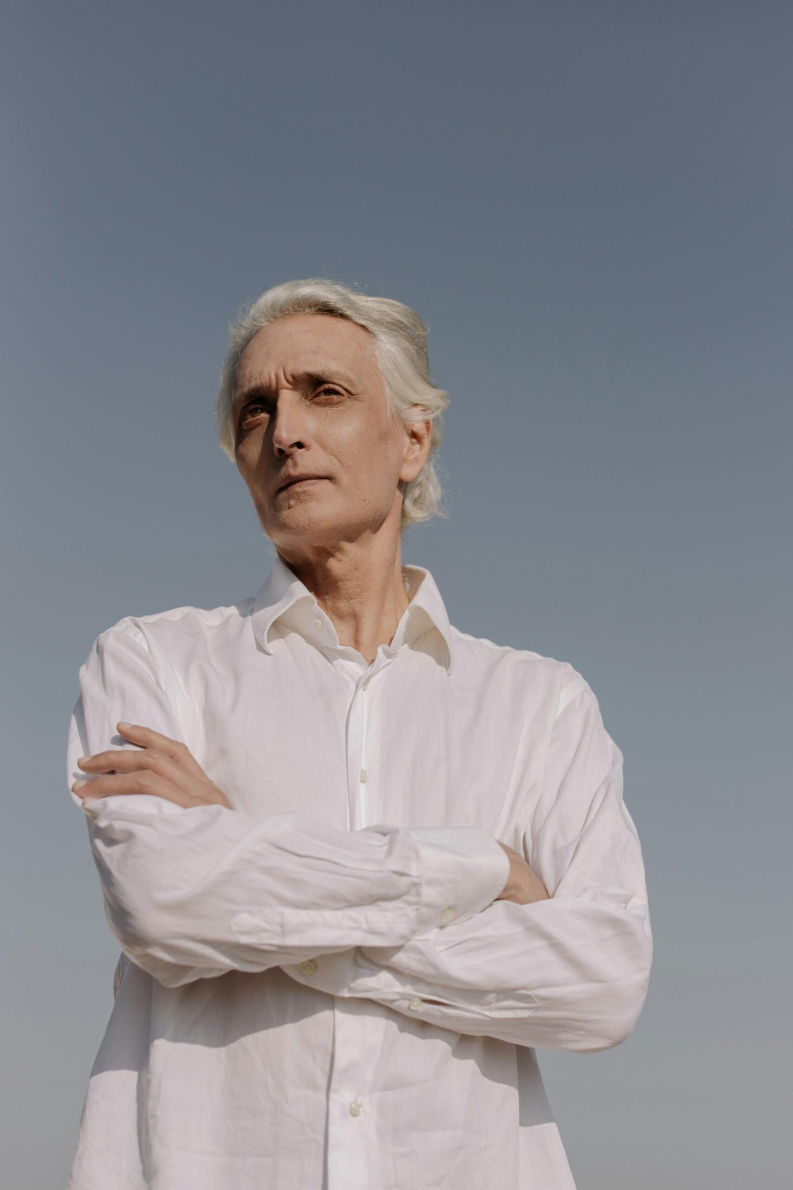 Older man standing with arms crossed, reflecting on life and renewed purpose