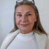 Confident woman over 40 smiling gently in a clean, minimal portrait