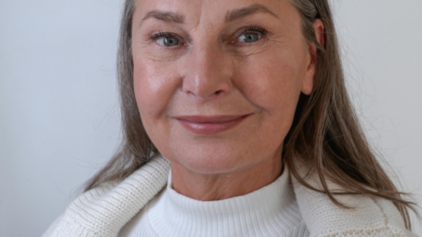 Confident woman over 40 smiling gently in a clean, minimal portrait