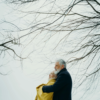 Older couple embracing outdoors under winter trees