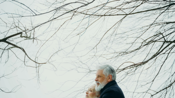 Older couple embracing outdoors under winter trees