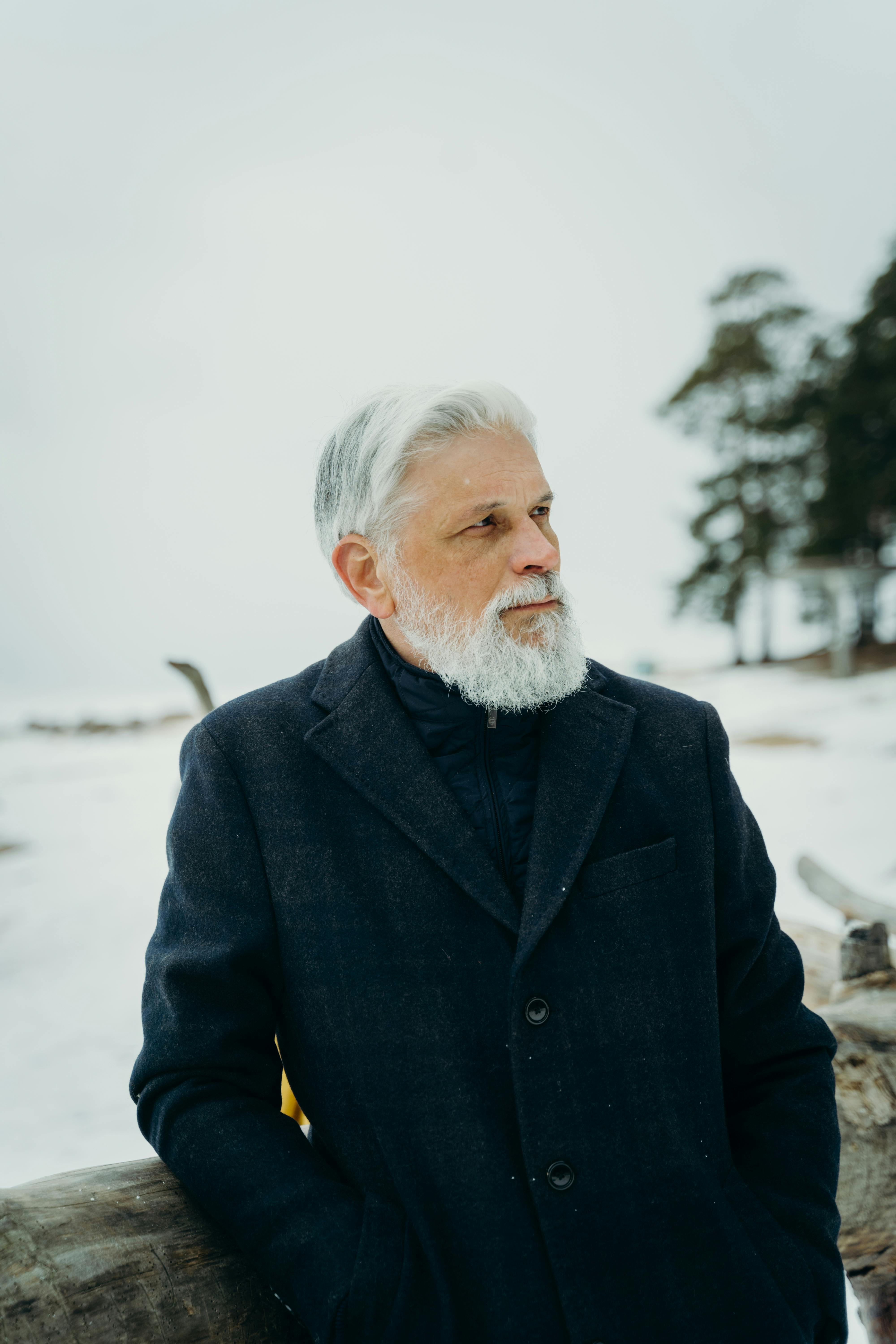 Older man with gray beard standing outdoors in winter, looking thoughtful and grounded