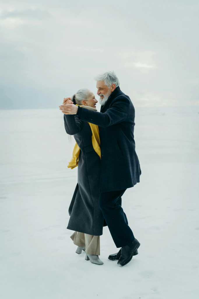Mature couple dancing together on a snowy landscape