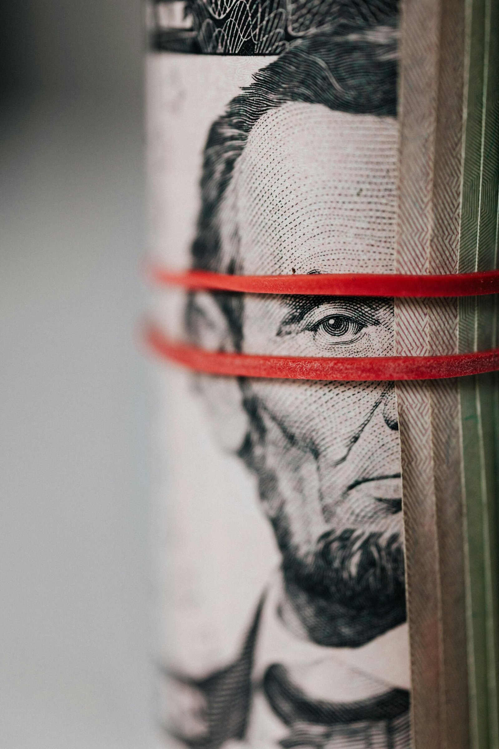 Close-up of rolled money secured with bands, symbolizing money habits and financial pressure