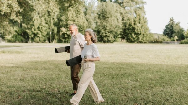 Mature couple walking outdoors carrying yoga mats during a relaxed fitness routine