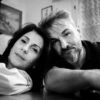 Black and white portrait of a middle-aged couple resting their heads together, showing quiet intimacy and emotional closeness at home