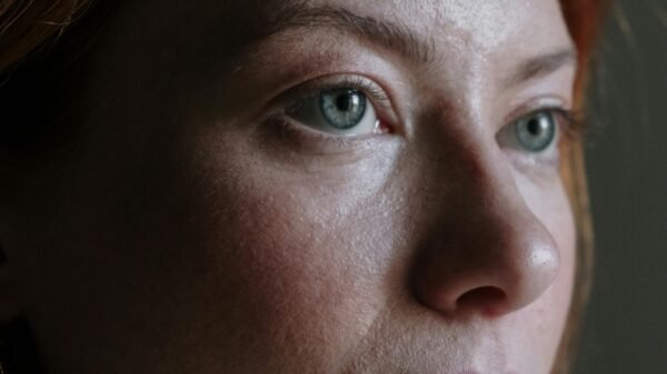 Woman in her 50s with red hair gazing thoughtfully, representing quiet confidence and inner strength