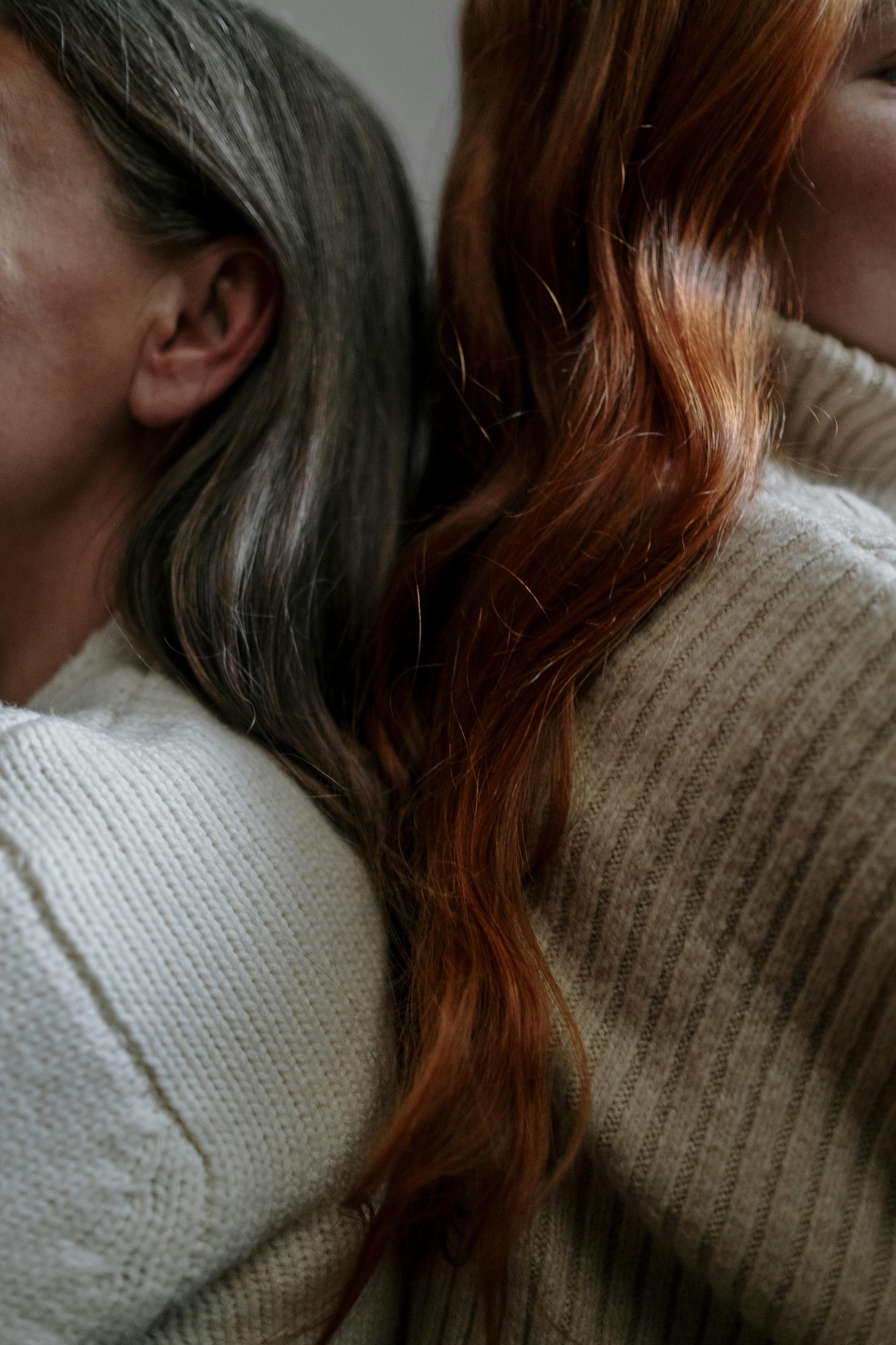 Older woman and younger woman sitting closely together, showing generational connection and shared presence