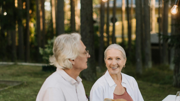 Older couple sitting at an outdoor table with their dog, enjoying a relaxed moment of connection and companionship
