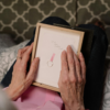 Woman holding a framed note with an engagement ring, symbolizing love and new beginnings