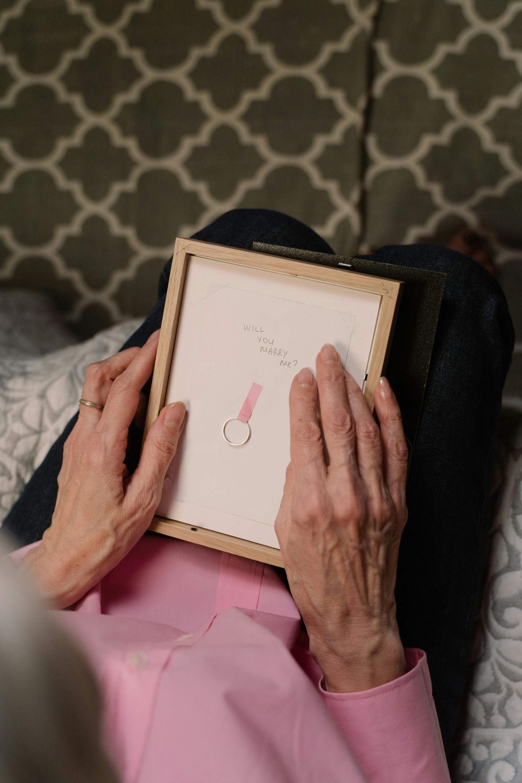 Woman holding a framed note with an engagement ring, symbolizing love and new beginnings