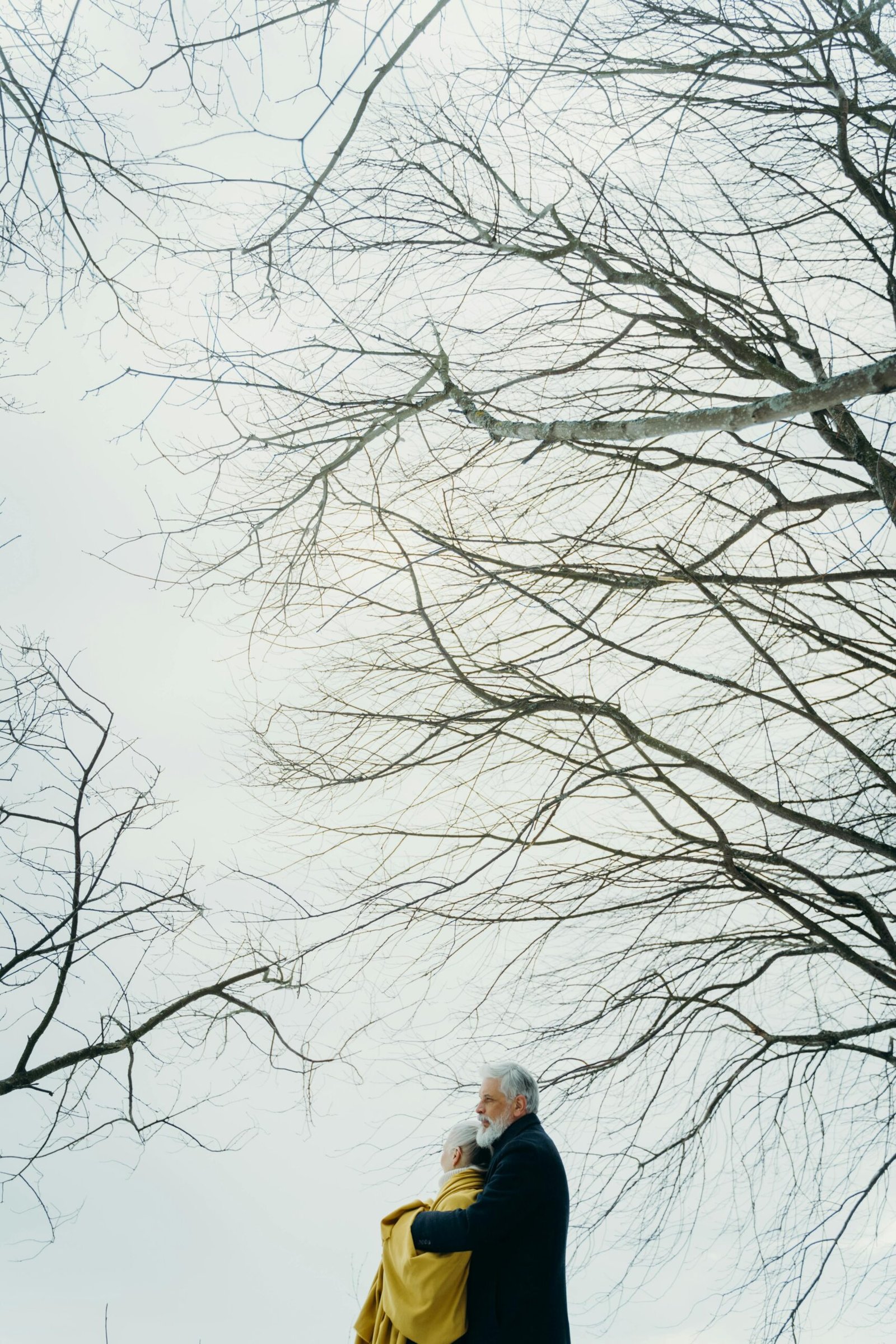 Mature couple embracing in a snowy landscape, expressing warmth, trust, and emotional closeness