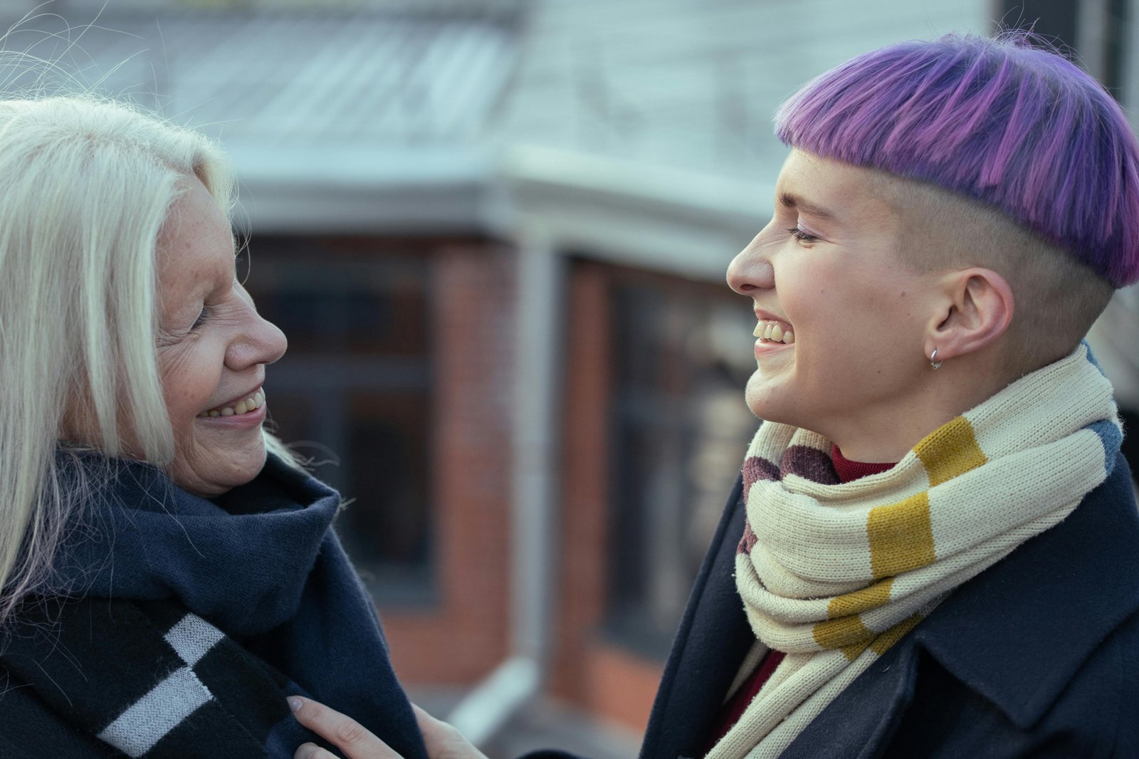 Older woman and younger person smiling and talking outdoors, reflecting intergenerational connection during retirement transition