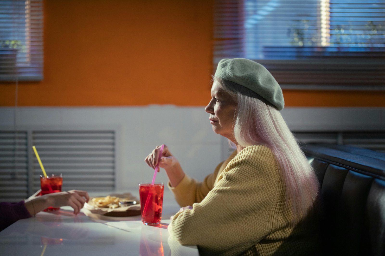 Woman in her 50s enjoying a relaxed moment at a diner, highlighting comfort, confidence, and personal style in midlife