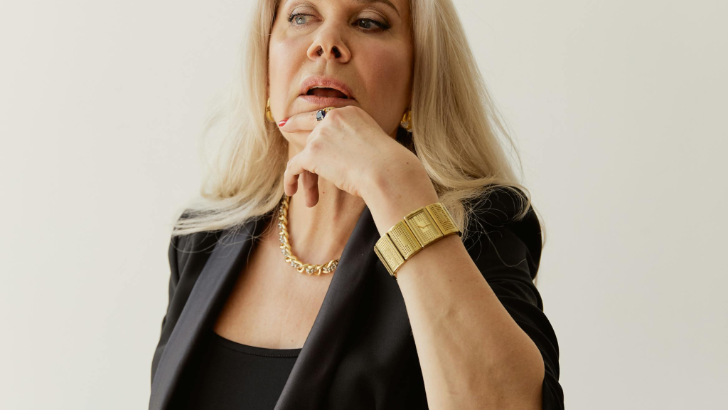 Thoughtful middle-aged woman sitting at a desk with a notebook, pausing while considering an important choice