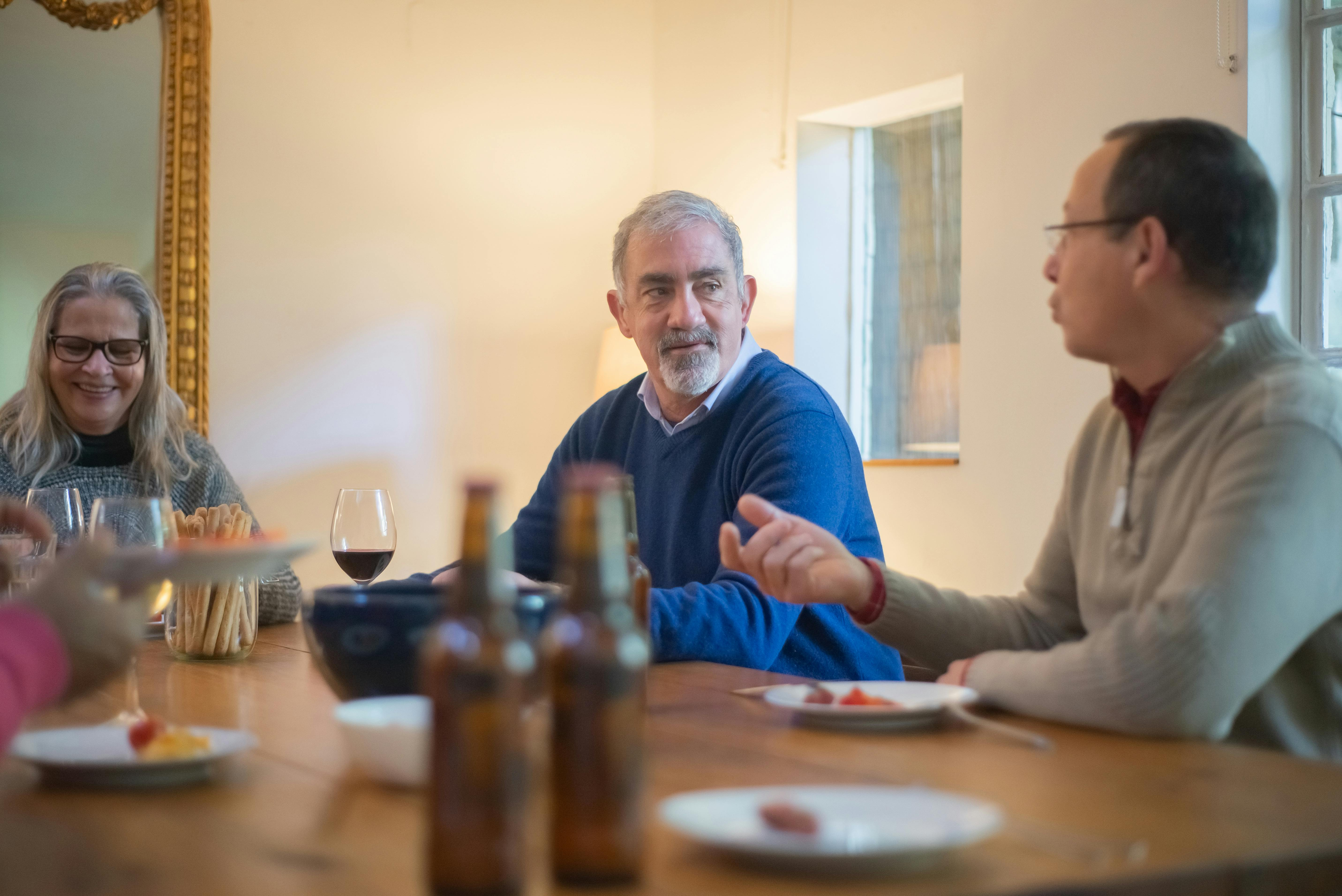 Middle-aged adults having a thoughtful conversation around a dinner table during a life transition phase