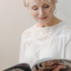 Woman in her 60s reading a book quietly, reflecting during a calm midlife moment