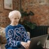 Confident woman in her 50s working on a laptop at home, embracing a simple and intentional life