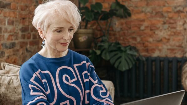 Confident woman in her 50s working on a laptop at home, embracing a simple and intentional life