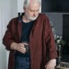 Middle-aged man standing in a kitchen holding a glass, reflecting quietly on life and personal choices