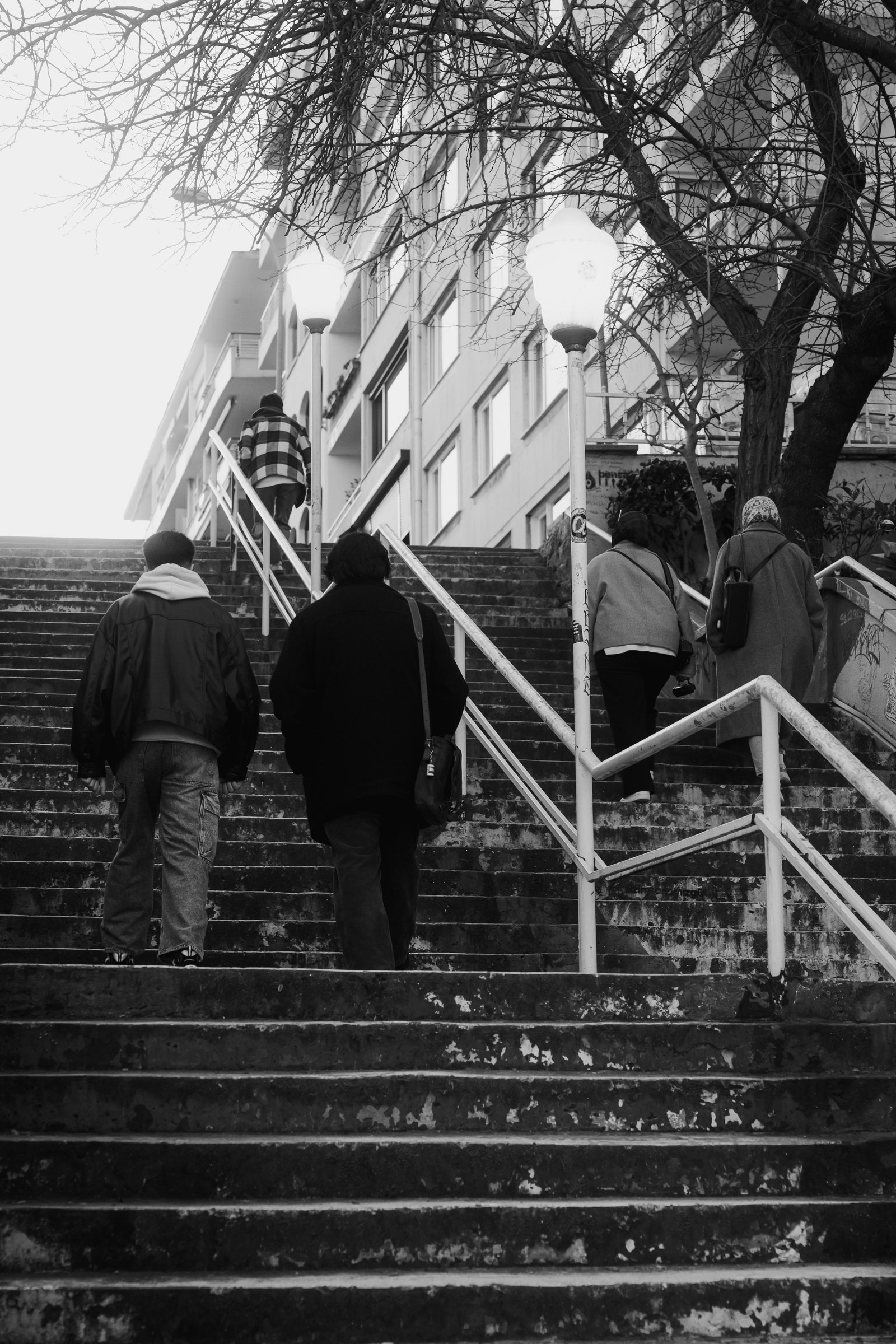 Group of people walking up city steps, symbolizing transition and quiet reflection