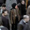 Person standing still while a crowd moves around them, expressing feeling disconnected in everyday life